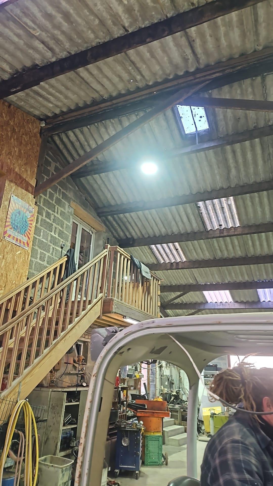 Technicien posant un luminaire LED en hauteur