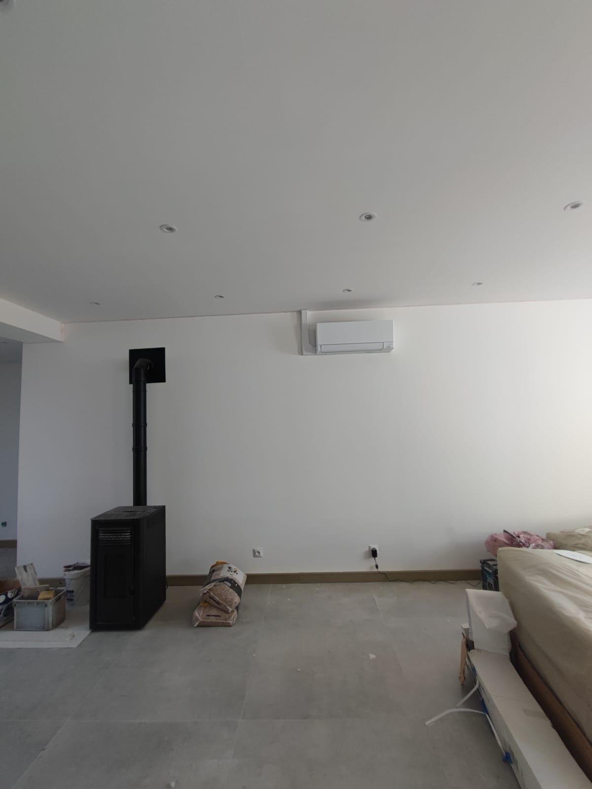 Poêle à granulés installé dans un salon avec climatisation réversible